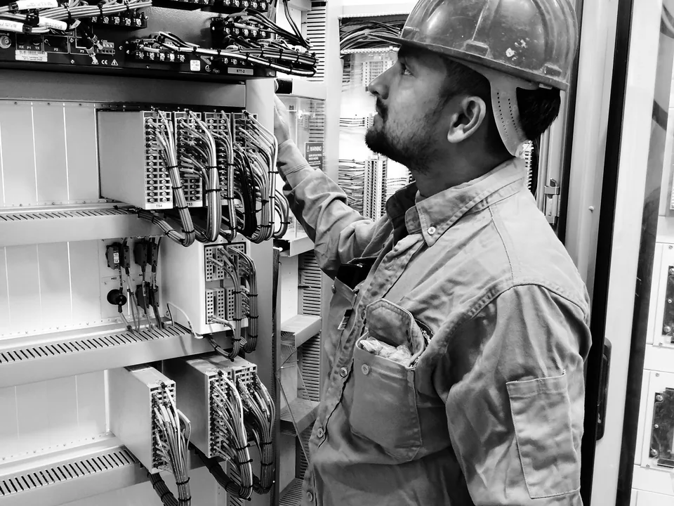 Technician checking cable connections in urban communication infrastructure