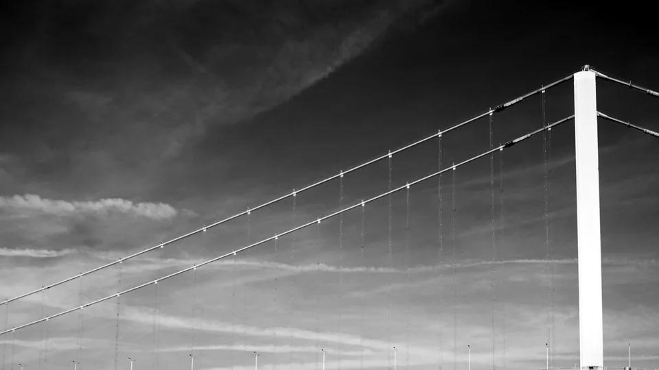 Bridge and suspension equipment carrying a communication line across water